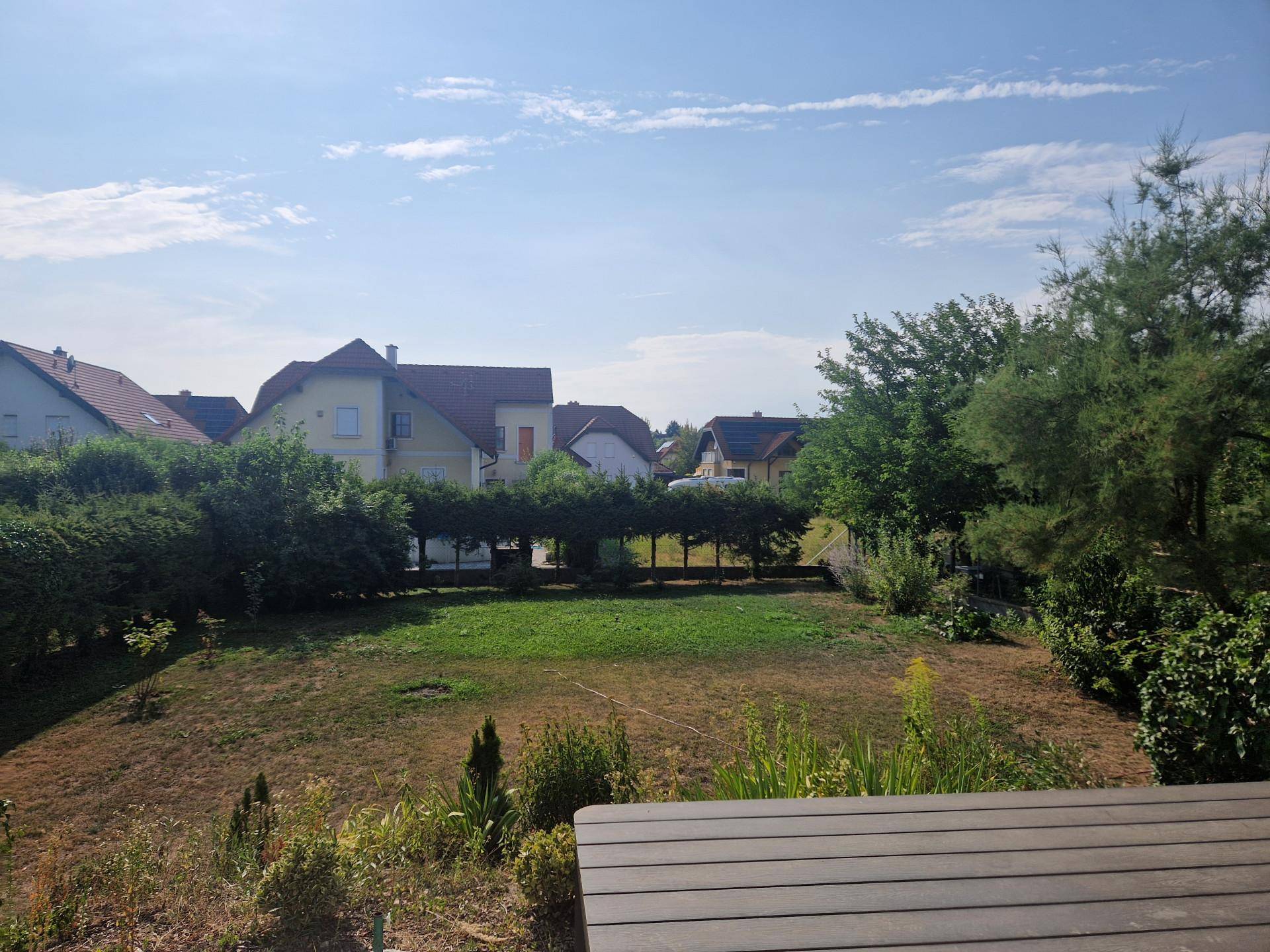 Weitläufiger Gartenbereich mit Rasenfläche und Blick auf die umliegenden Häuser.