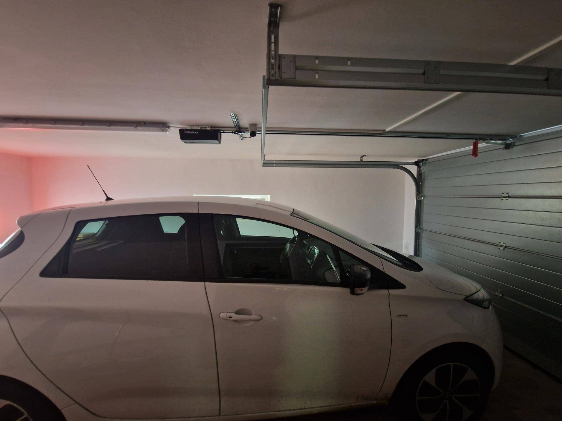 Geräumige Garage mit automatischem Tor und Platz für ein Fahrzeug.