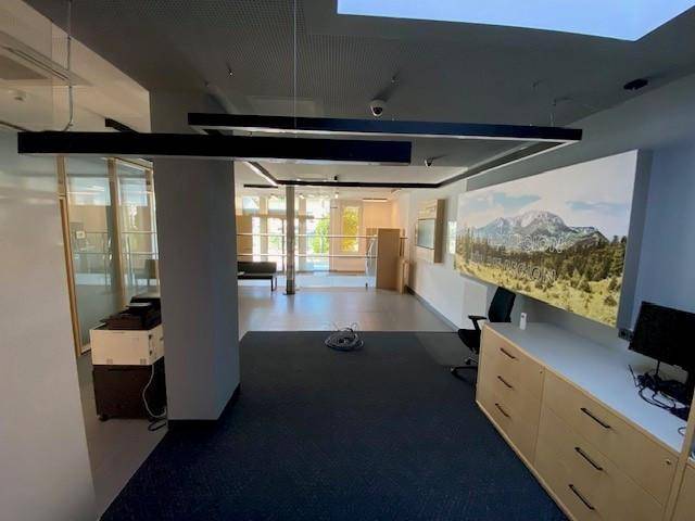 Moderner Bürobereich mit Teppichboden, Schreibtisch und dekorativer Wandgestaltung in einer Bankfiliale.