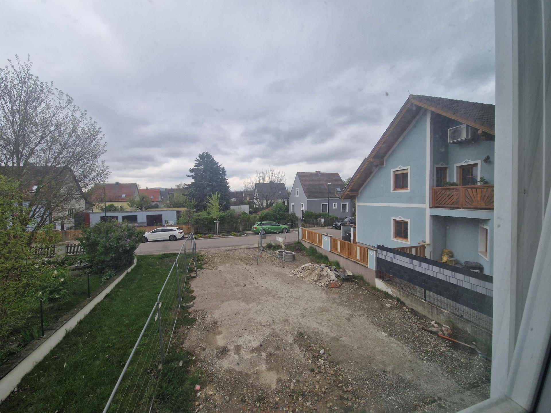 Blick auf die ländliche Umgebung mit weiteren Häusern und viel Grünfläche.