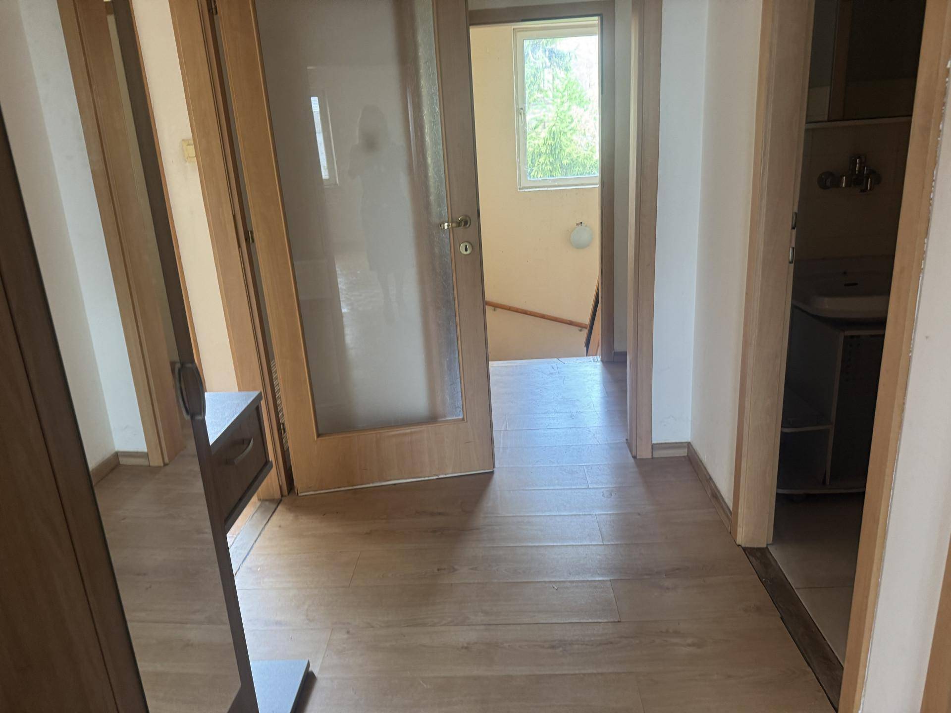 Heller Flur mit Laminatboden, Spiegelschrank und Türen, die zu den verschiedenen Räumen führen.