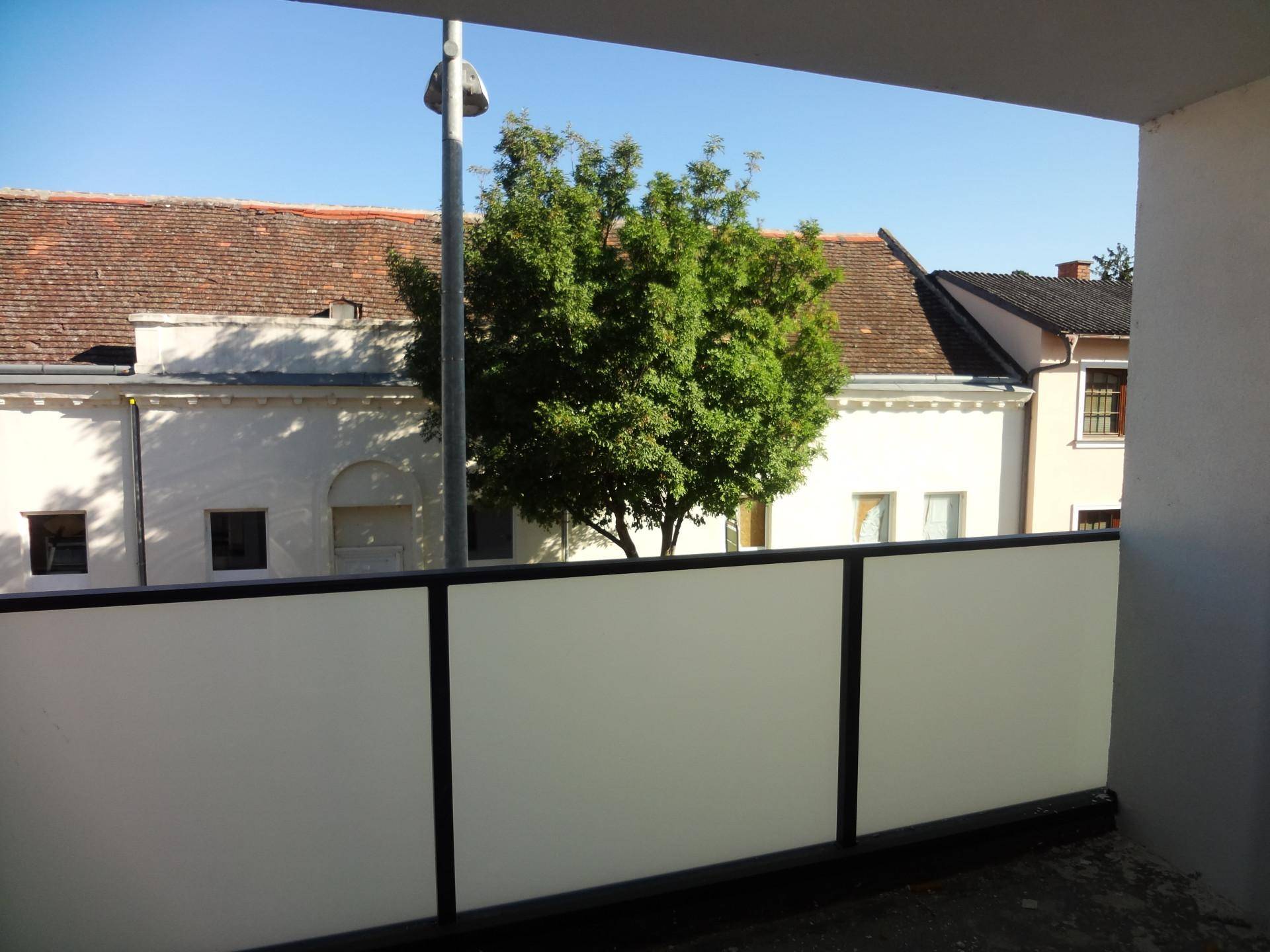 Blick vom Balkon auf die gegenüberliegenden Gebäude und die Straße.