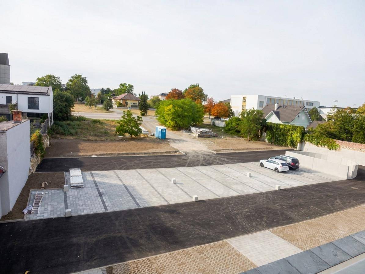 Weitläufiger Außenbereich mit Parkplätzen und unbebautem Land in der Umgebung.