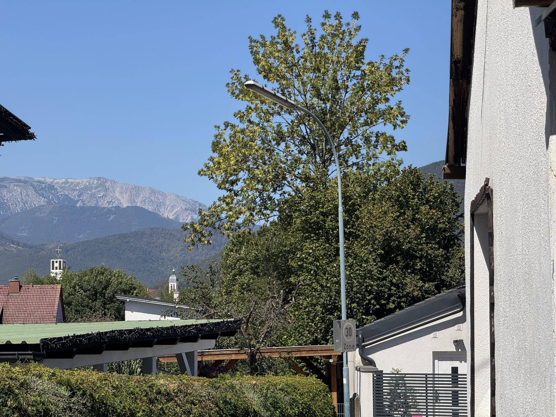Panoramablick auf die umliegende Landschaft mit Bergen im Hintergrund und klarem Himmel.