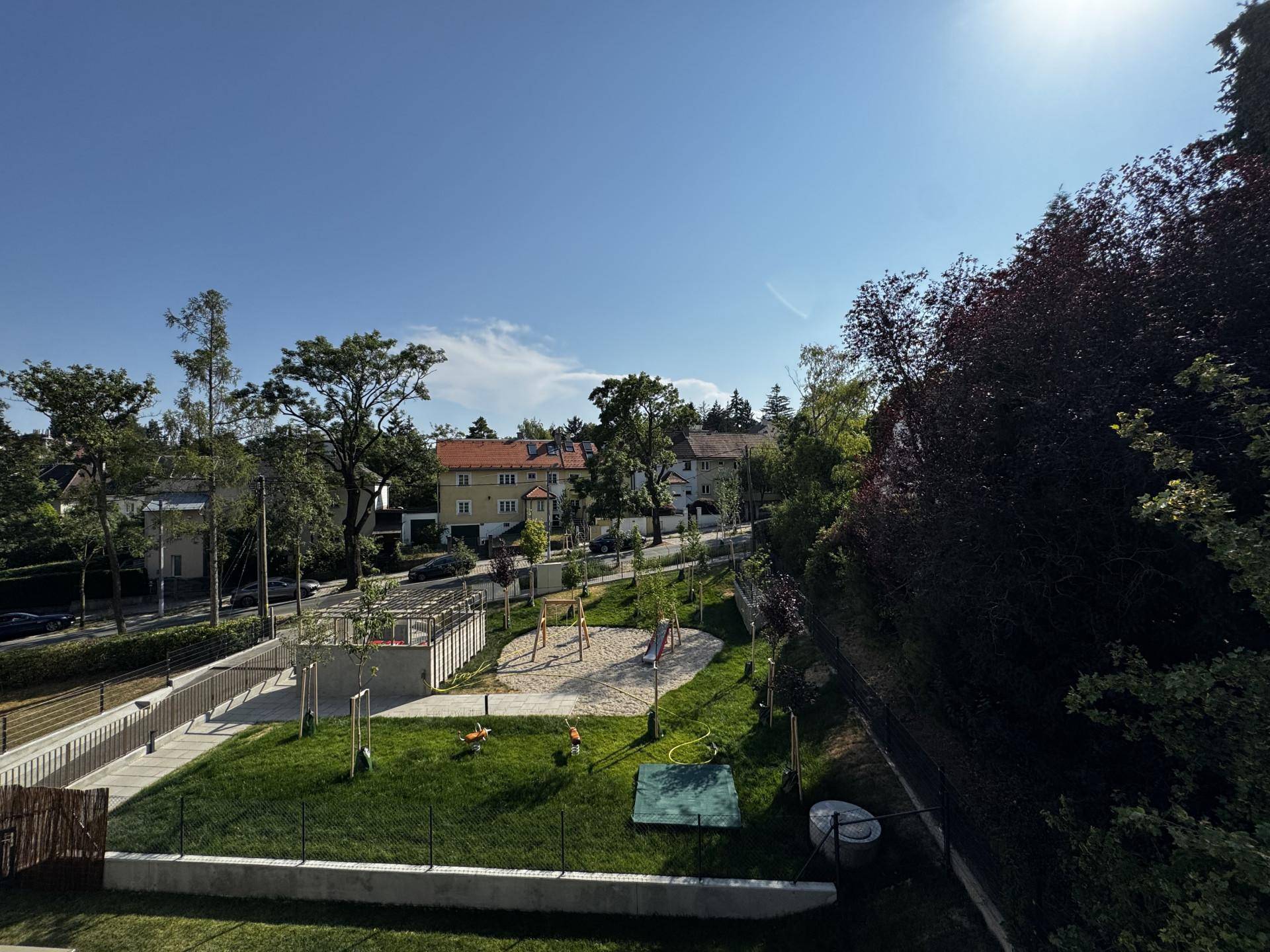 Gemeinschaftlicher Gartenbereich mit Spielplatz und viel Grün für Kinder und Erholung.