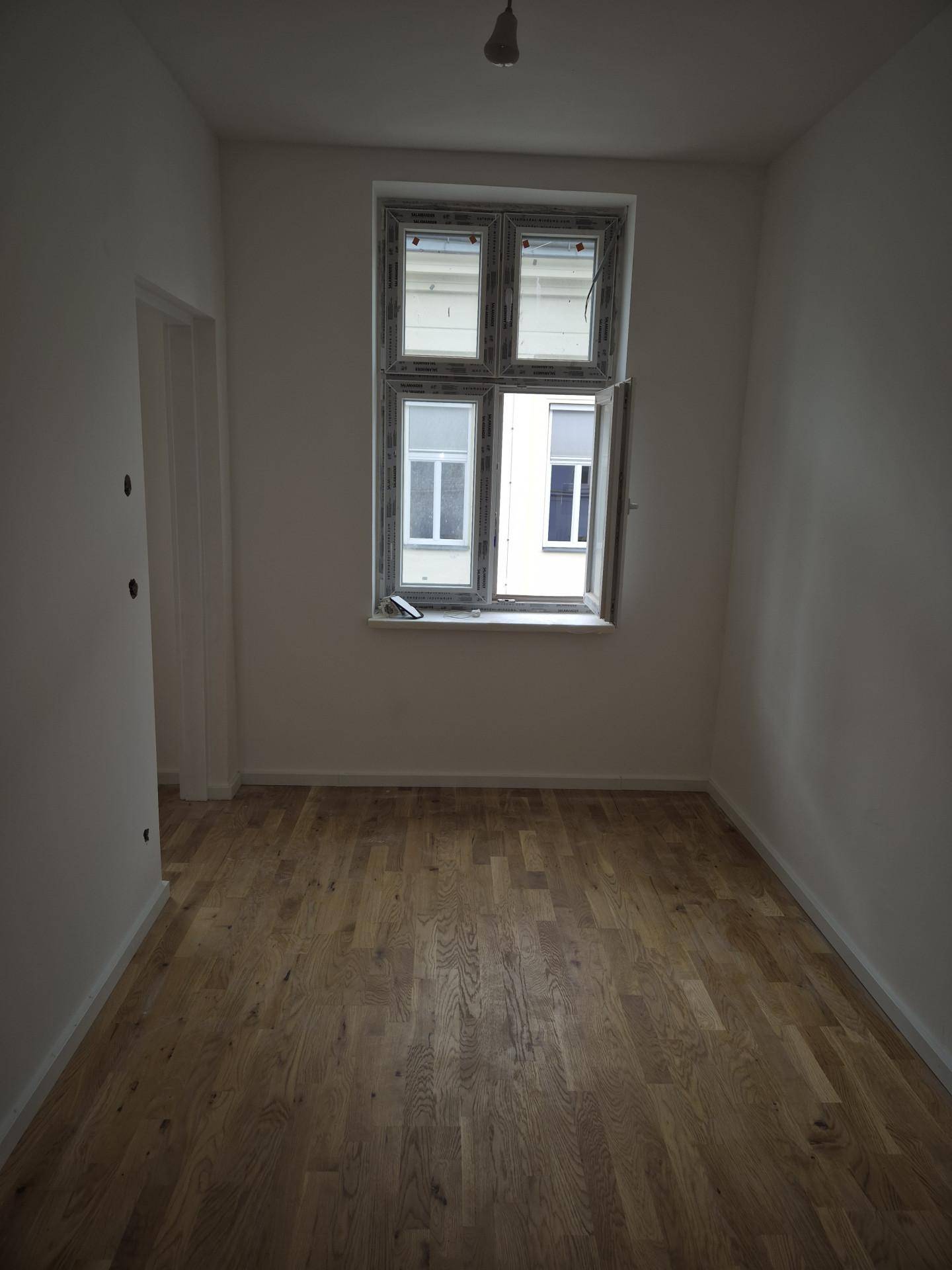 Heller Raum mit neuem Parkettboden und einem Fenster, ideal als Schlafzimmer oder Kinderzimmer.