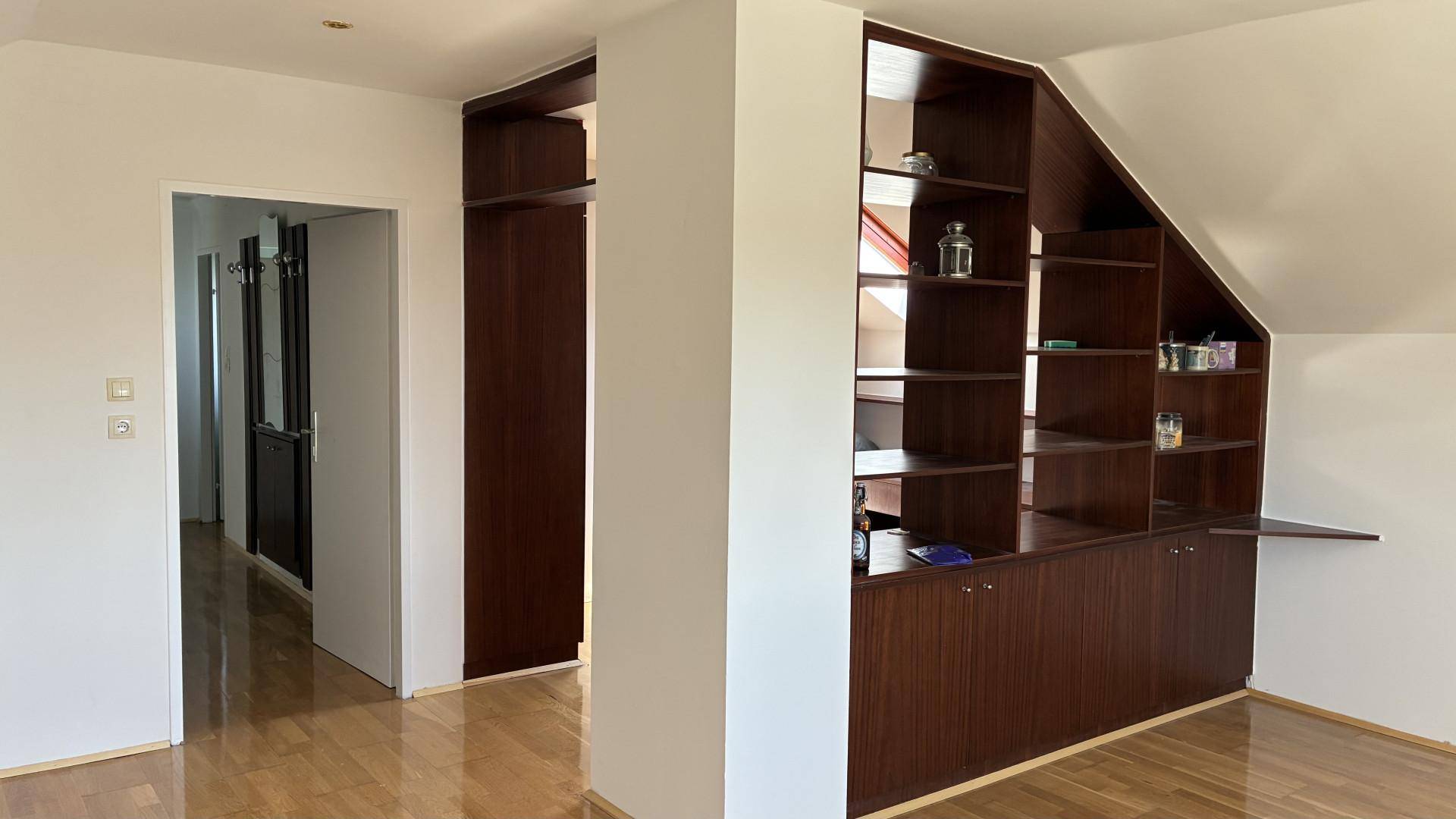 Flur im Dachgeschoss mit maßgefertigten Einbauregalen unter der Dachschräge.