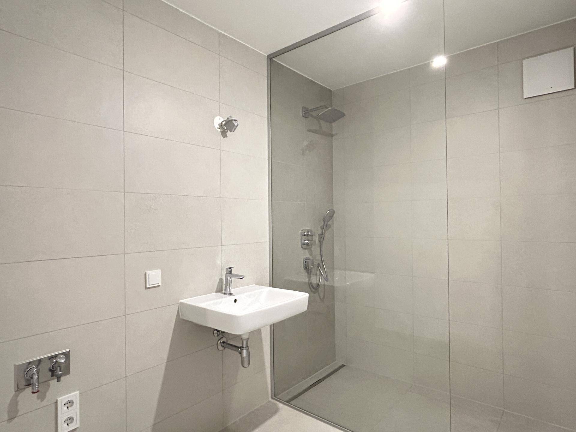 Modernes Badezimmer mit ebenerdiger Dusche und eleganten Fliesen.