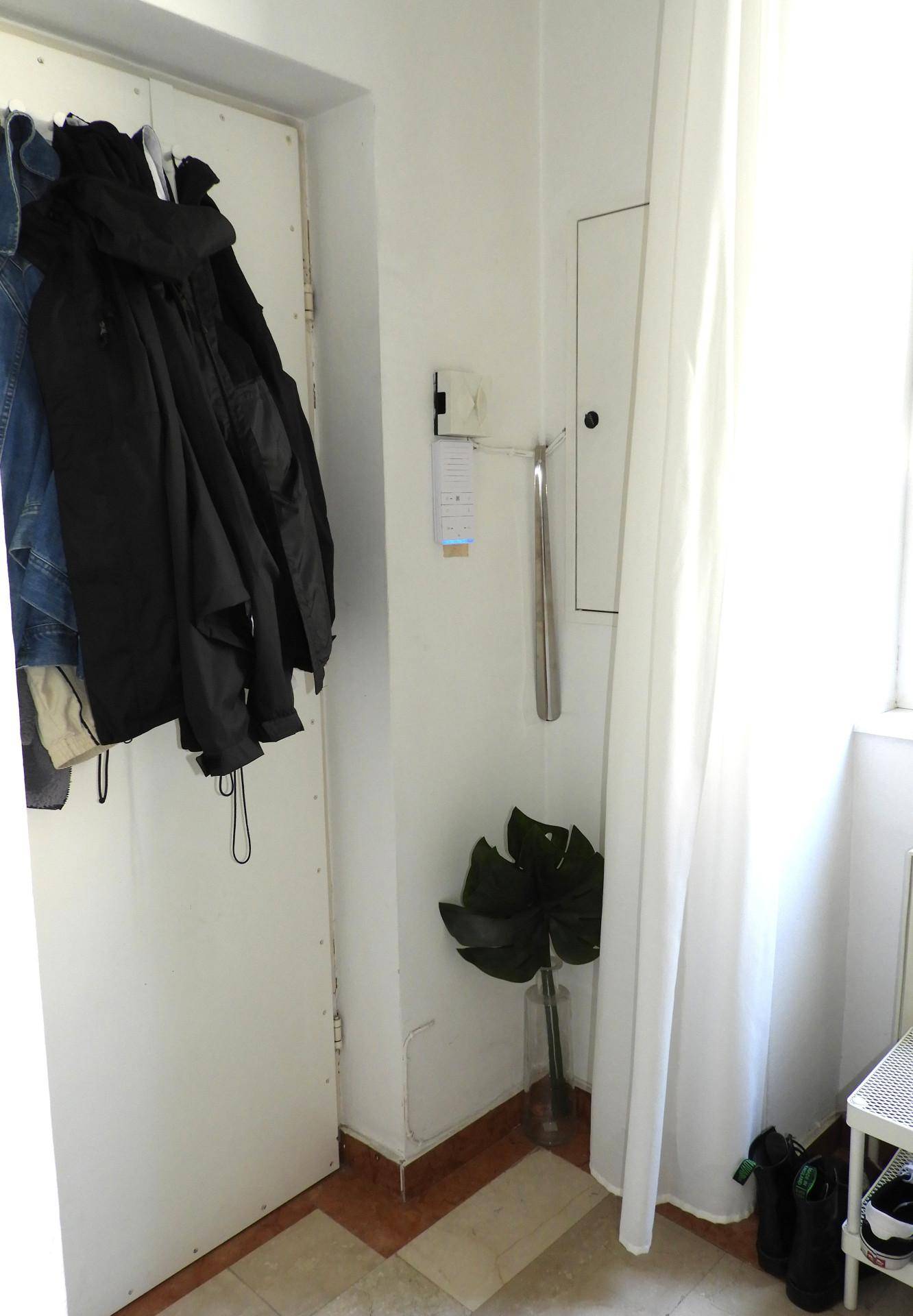 Heller Eingangsbereich mit Garderobe, Fliesenboden und einem Fenster für Tageslicht.