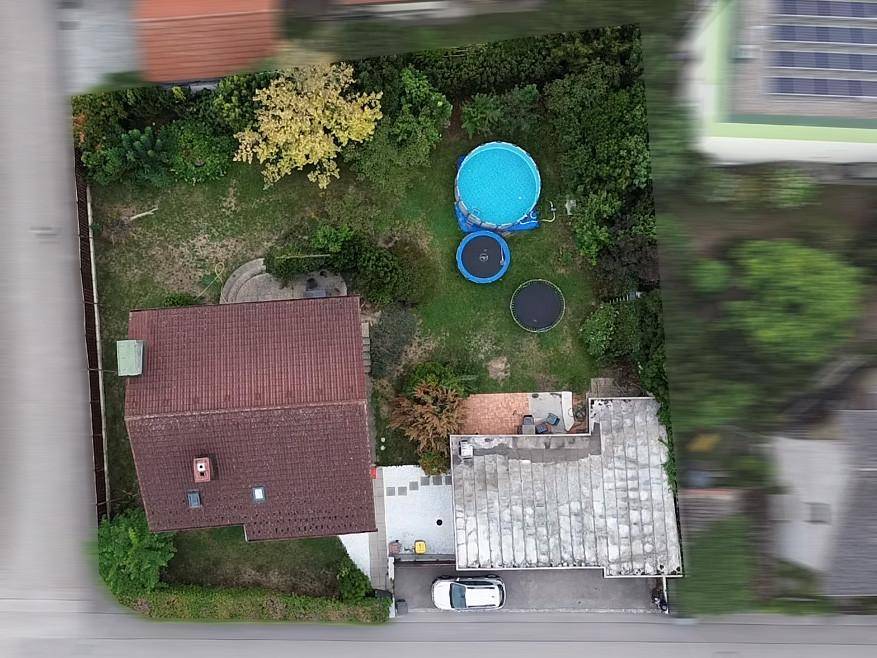 Luftaufnahme des Gartens mit Pool, Trampolin und viel Grünfläche hinter dem Haus.