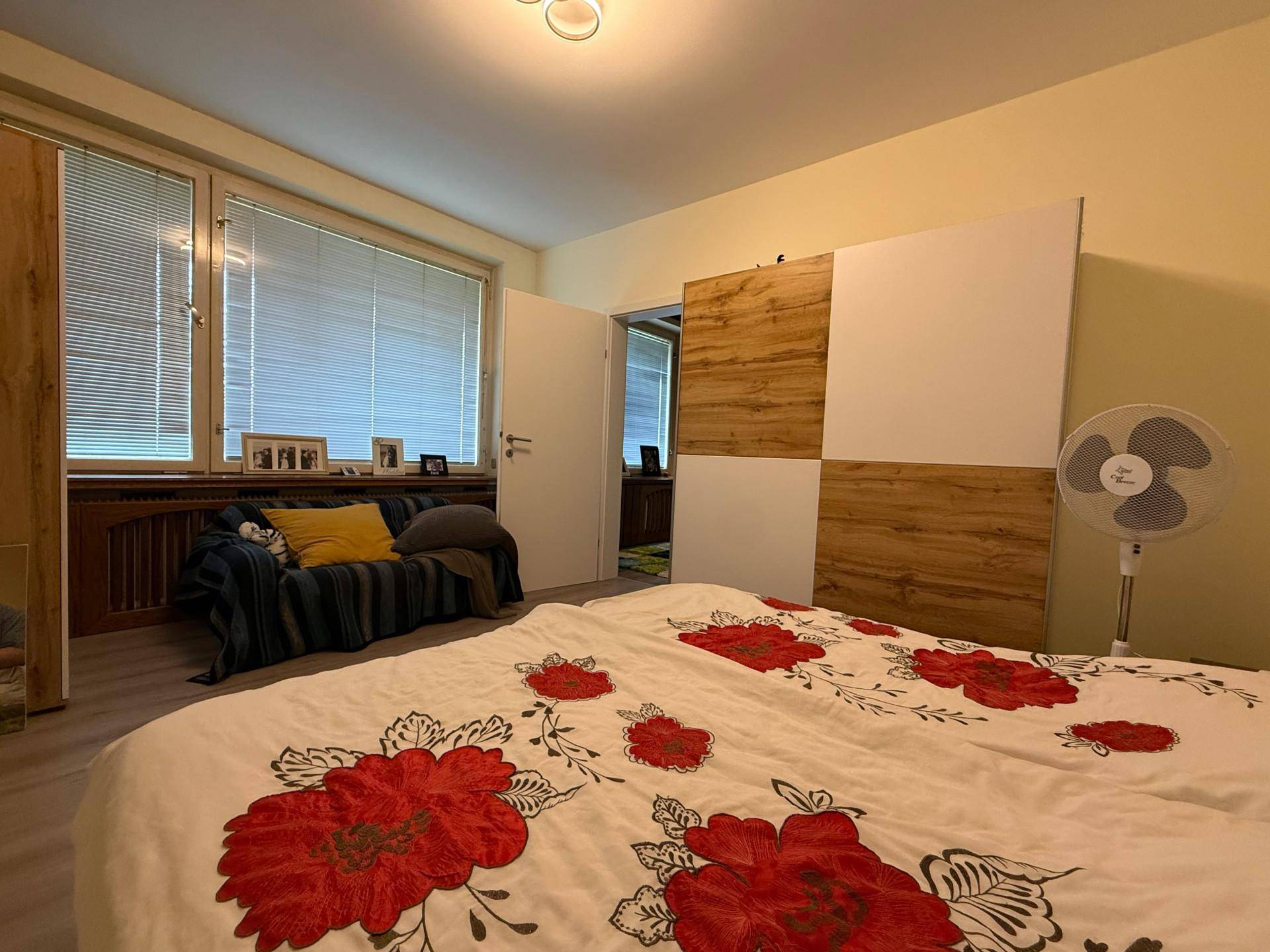 Helles Schlafzimmer mit großem Bett, Fenster und modernem Schrankdesign.