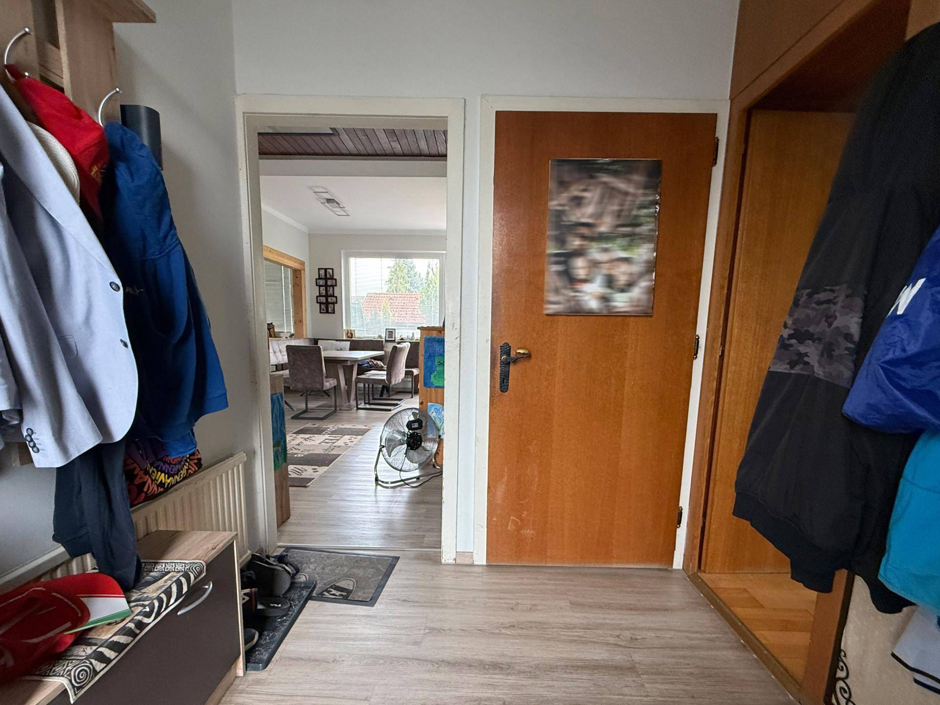 Eingangsbereich mit Garderobe und Blick in den offenen Wohn-Essbereich.