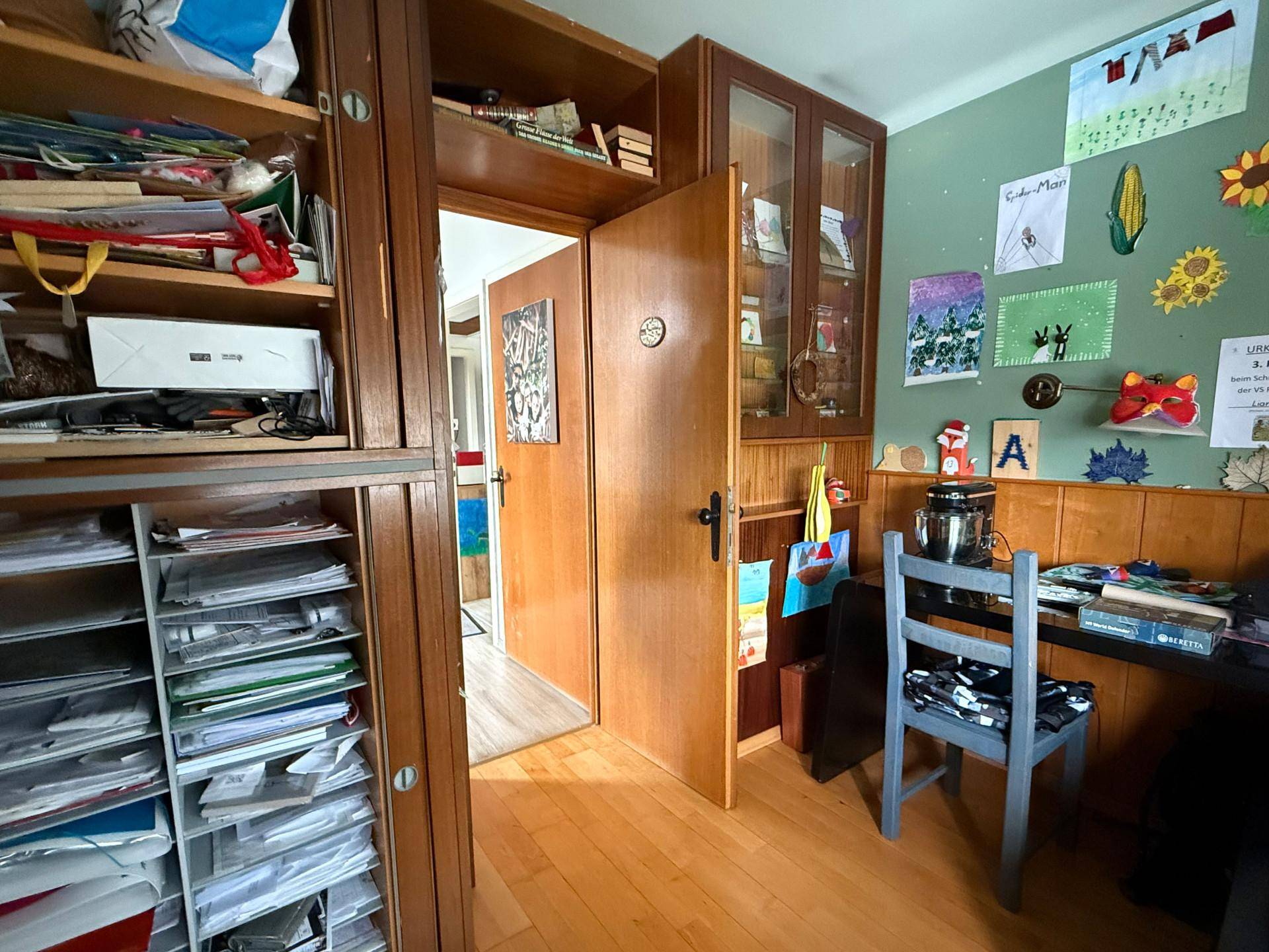 Arbeitszimmer mit Holzvertäfelung, Bücherregalen und einem Schreibtischbereich.