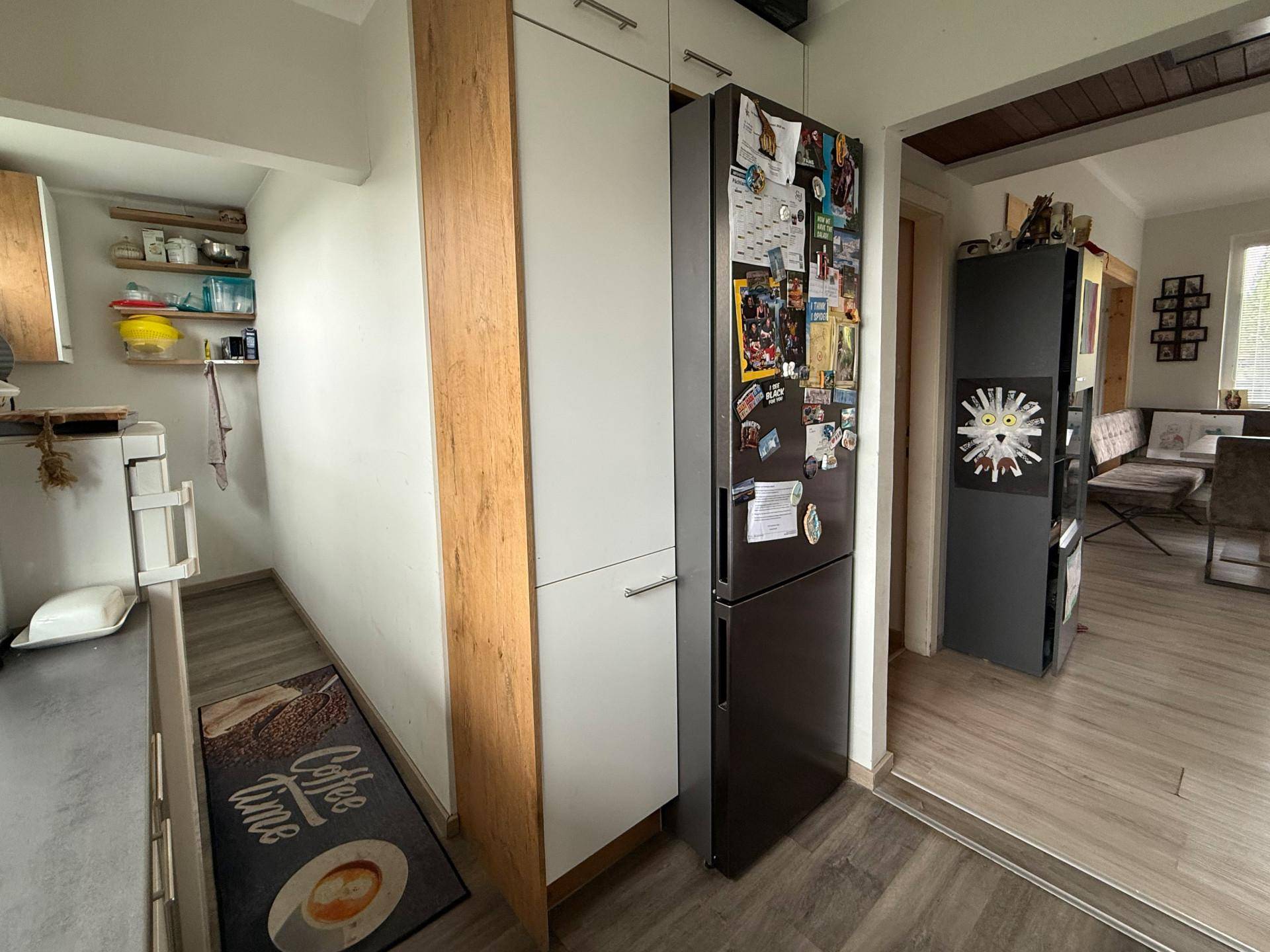 Küchenzeile mit integriertem Kühlschrank und Übergang zum Wohnbereich.