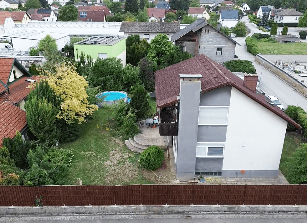 Luftaufnahme des Gartens mit Haus, Pool und der umliegenden Wohngegend.