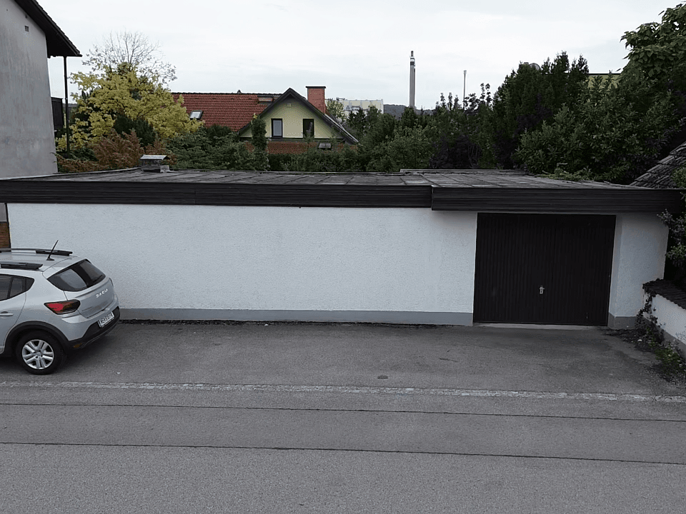 Luftaufnahme einer Garage neben der Straße mit einem geparkten Auto.