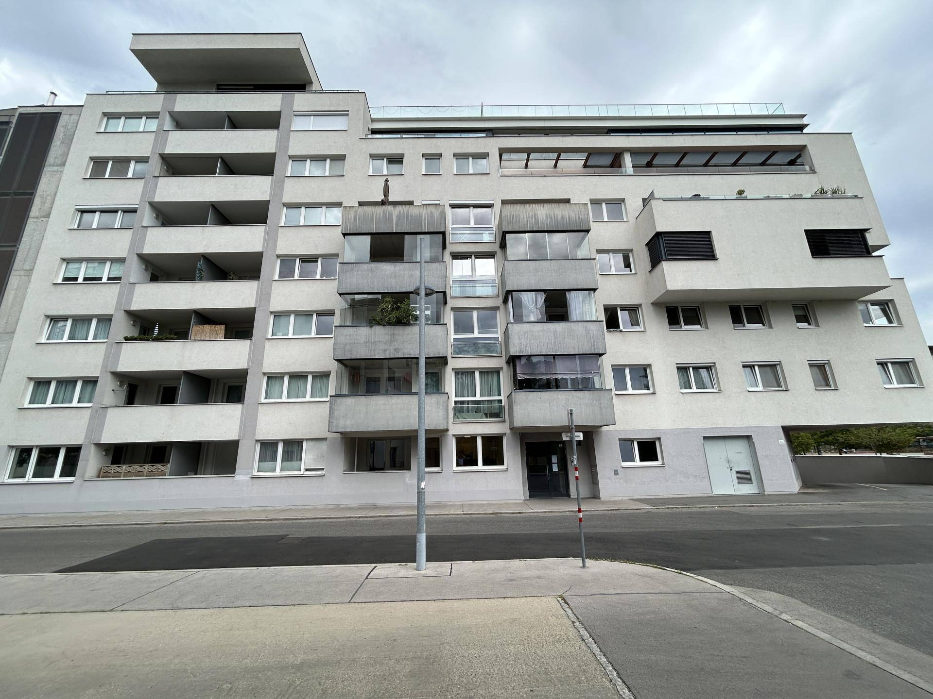Moderne Wohngebäude-Fassade mit Balkonen und großen Fenstern, die eine zeitgemäße Architektur zeigt.