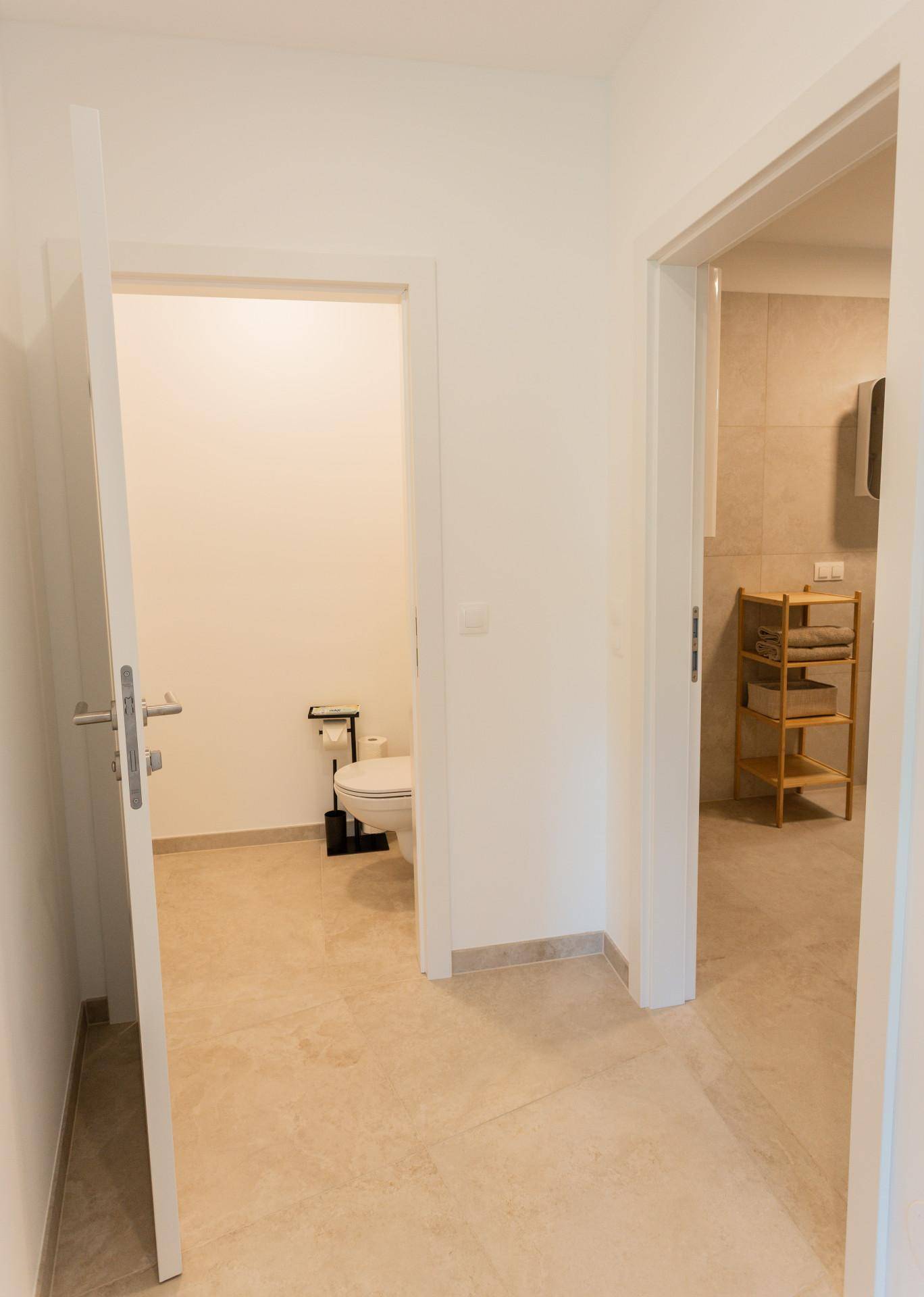 Heller Flur mit Zugang zu einem separaten WC und einem modernen Badezimmer.