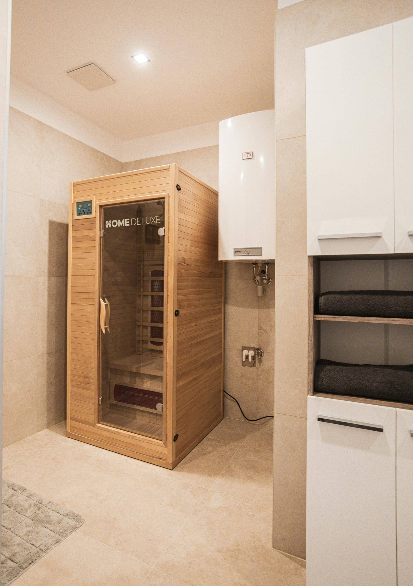 Wellnessbereich im Badezimmer mit einer modernen Infrarotsauna und Stauraum.