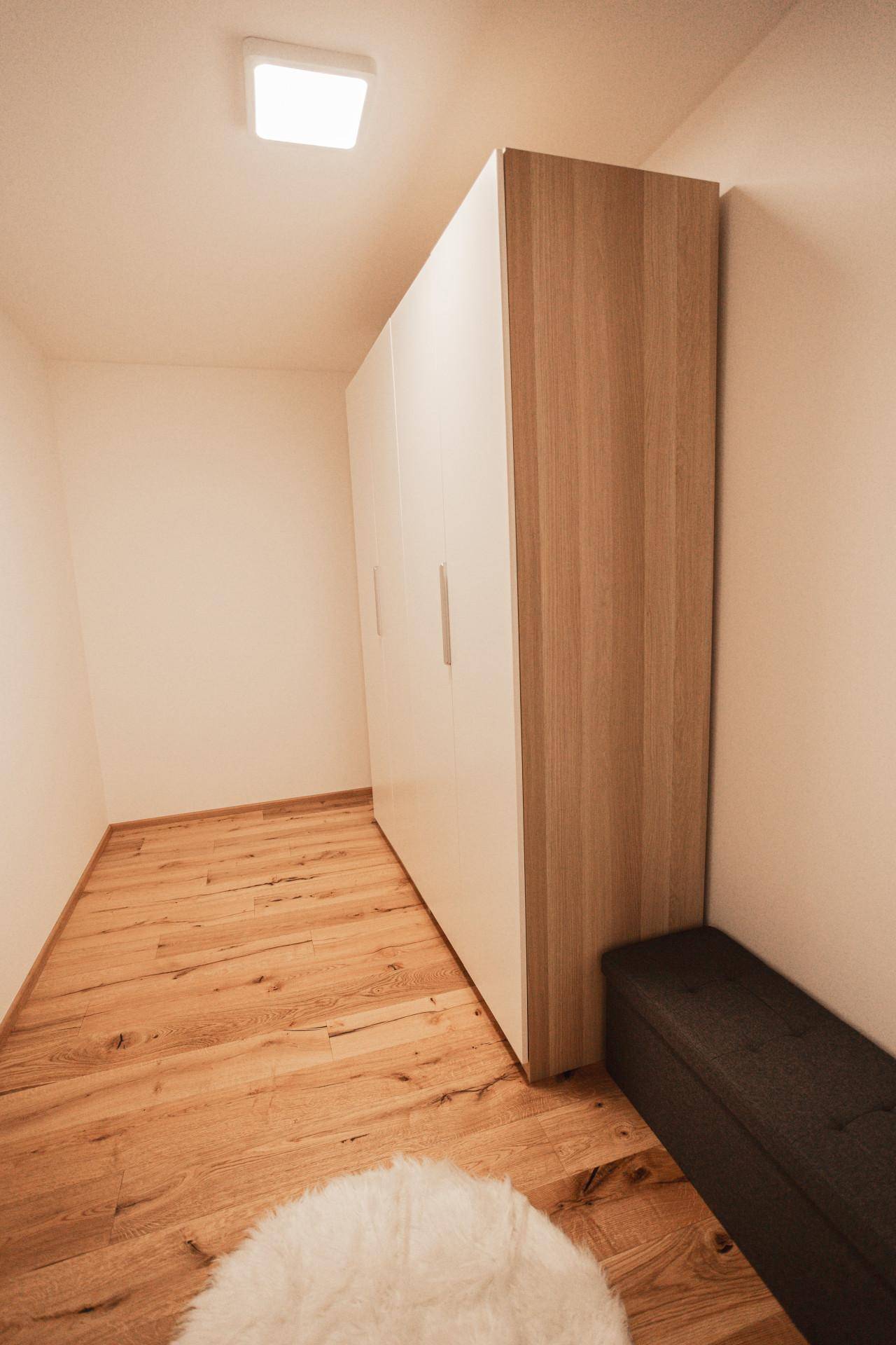 Kleiner Raum mit großem Kleiderschrank und Holzboden.