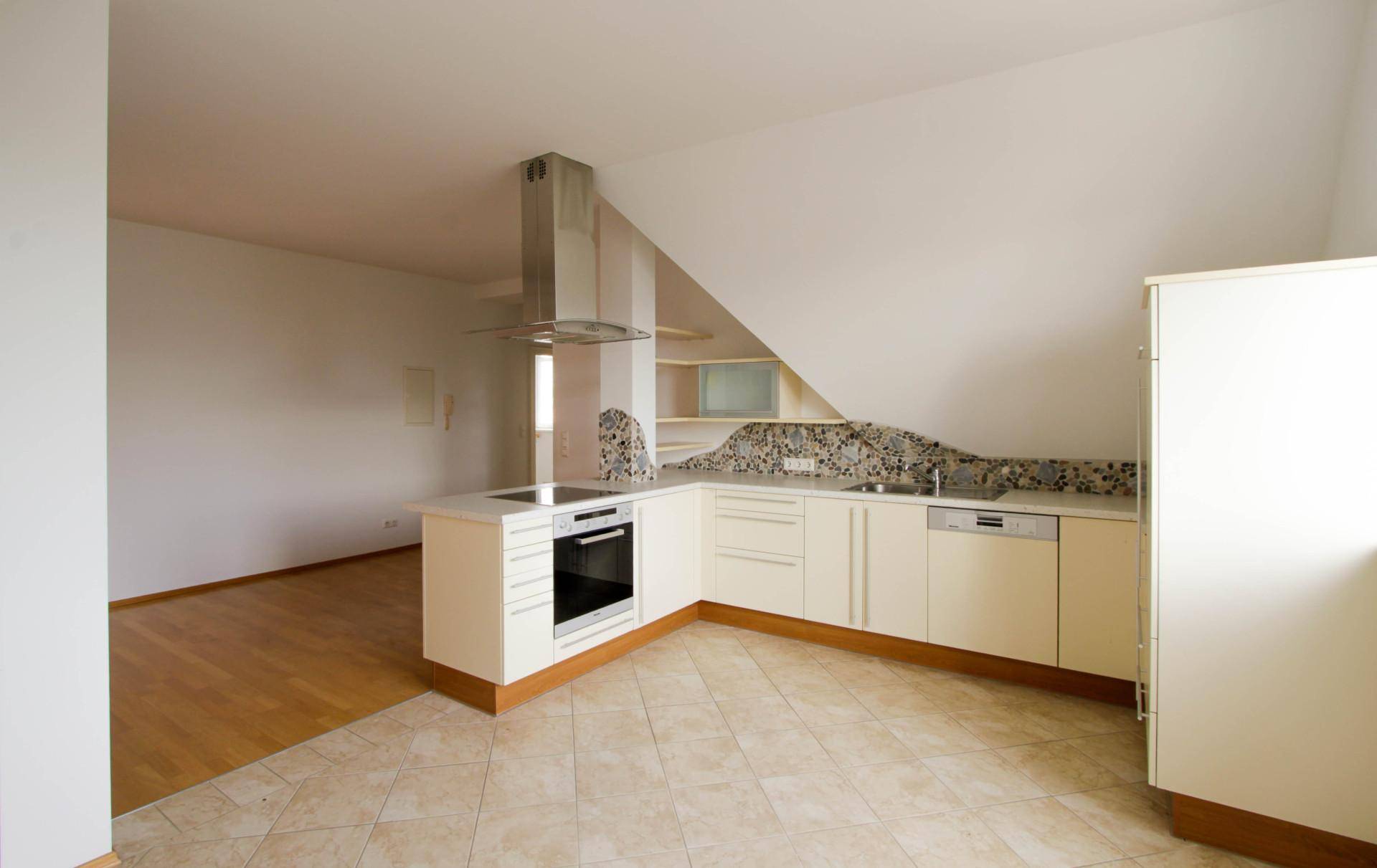 Moderne Einbauküche mit weißen Schränken, integrierten Geräten und einer stilvollen Dunstabzugshaube.