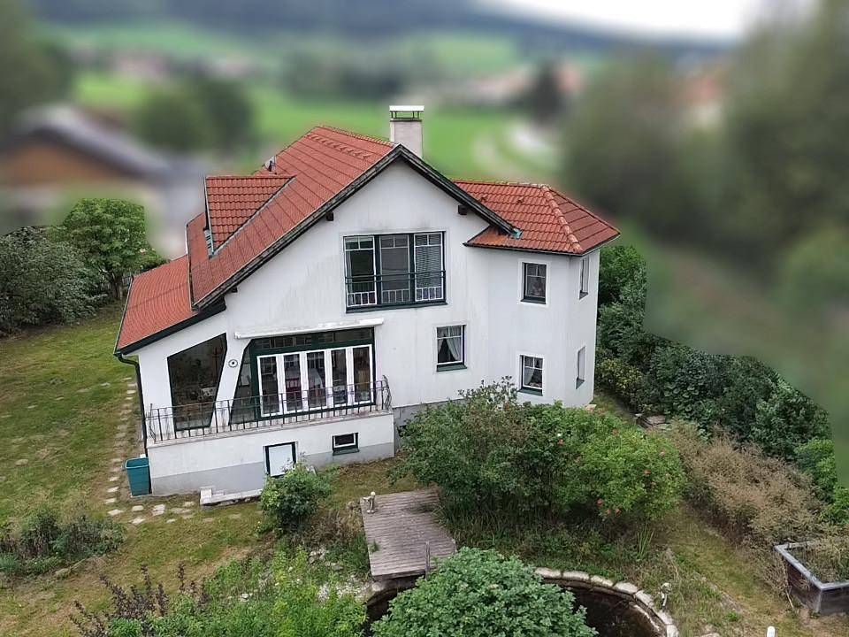 Luftaufnahme des Hauses mit rotem Ziegeldach und umliegendem Grundstück in ländlicher Umgebung.