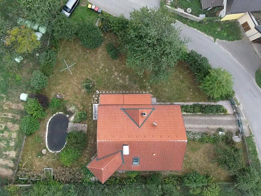 Vogelperspektive des Anwesens mit Haus, Garten, Teich und Zufahrt.