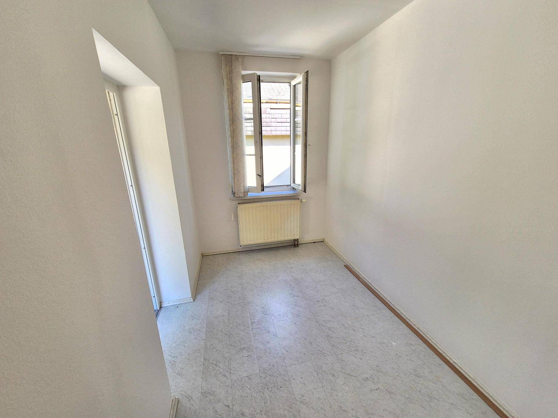 Kleiner, heller Raum mit Fenster und einfachem Bodenbelag, ideal als Schlaf- oder Gästezimmer.