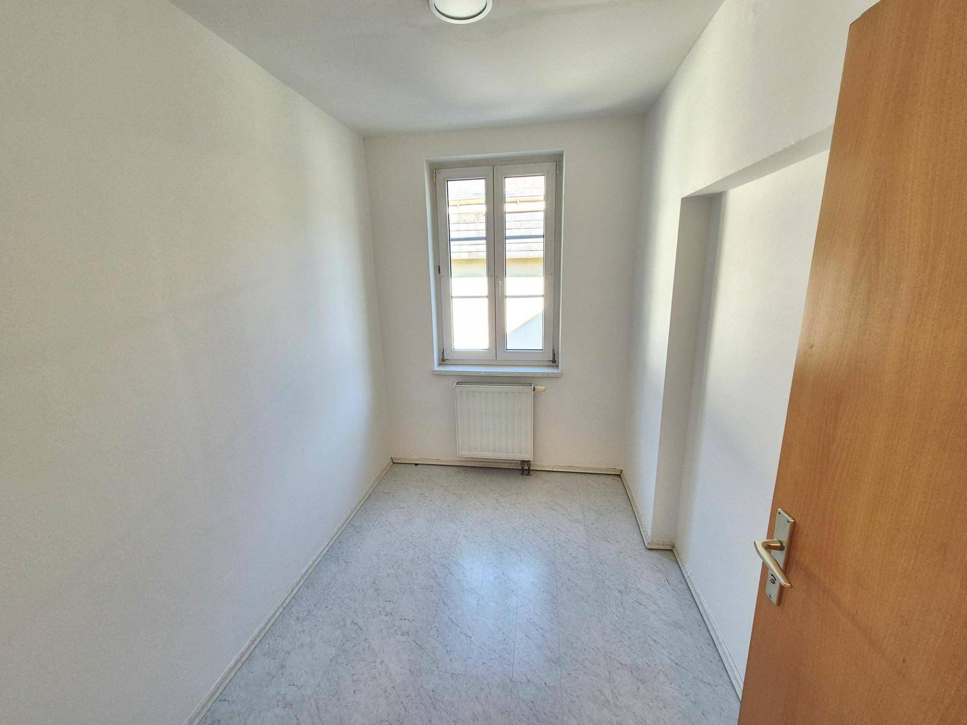 Kleiner, heller Raum mit Fenster und einfachem Bodenbelag, ideal als Schlaf- oder Arbeitszimmer.