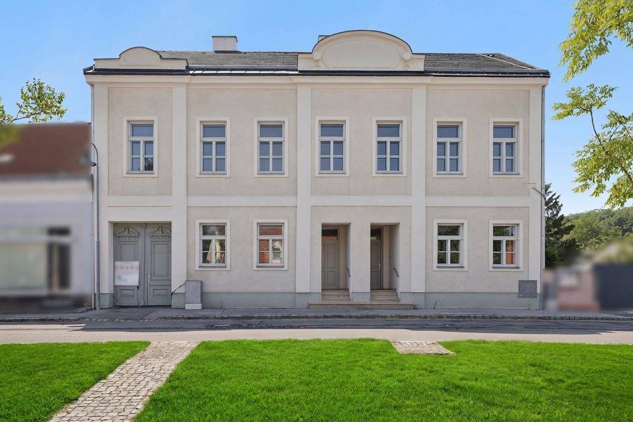 Vorderansicht eines gepflegten Altbaus mit symmetrischer Fassade und traditionellem Eingangsbereich.