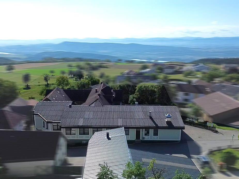 Weitläufige Luftaufnahme des Anwesens mit Blick auf die umliegende grüne Landschaft und ferne Berge.