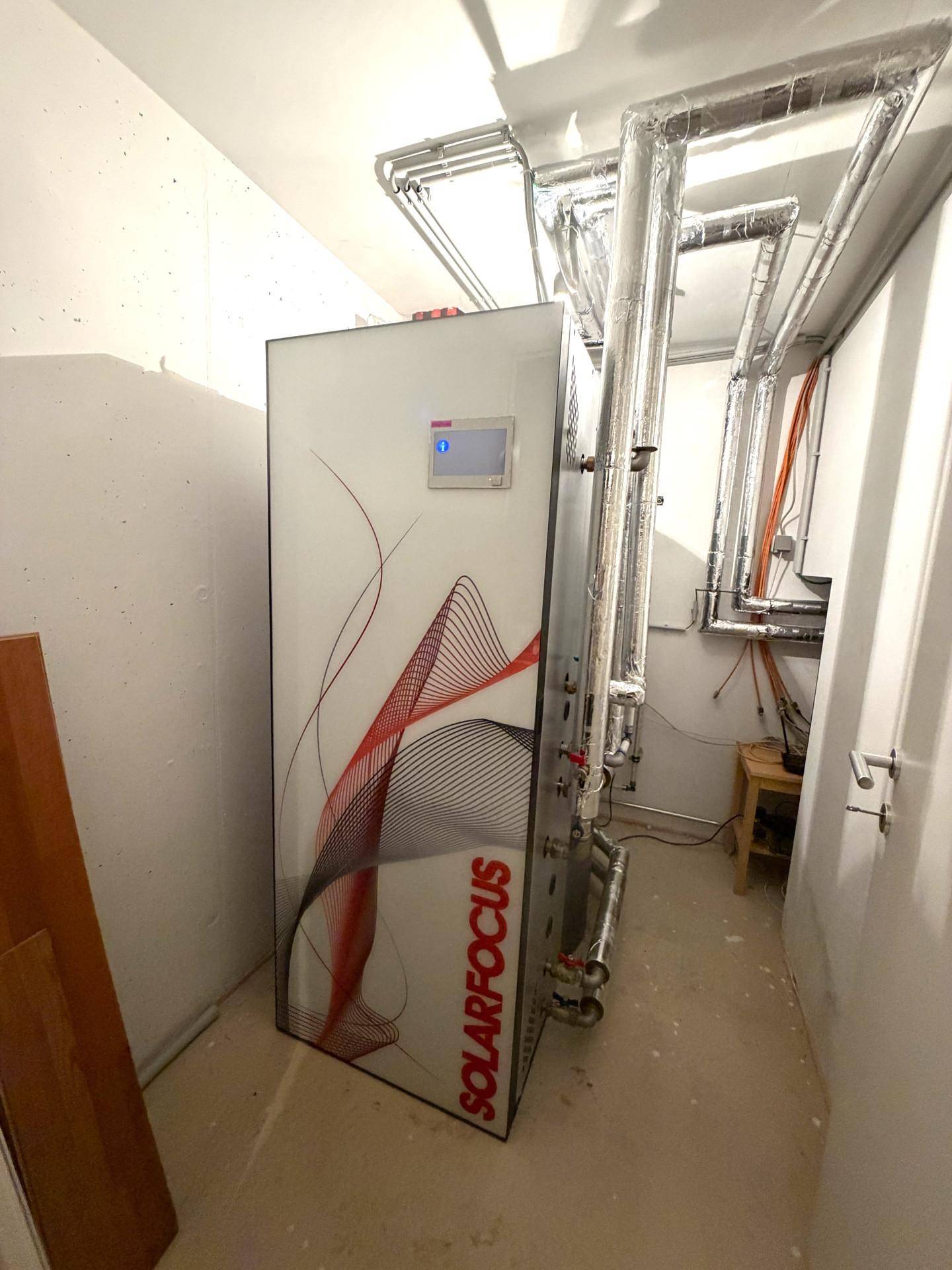 Heizungsraum mit moderner Solaranlage und isolierten Rohrleitungen für effiziente Energieversorgung.