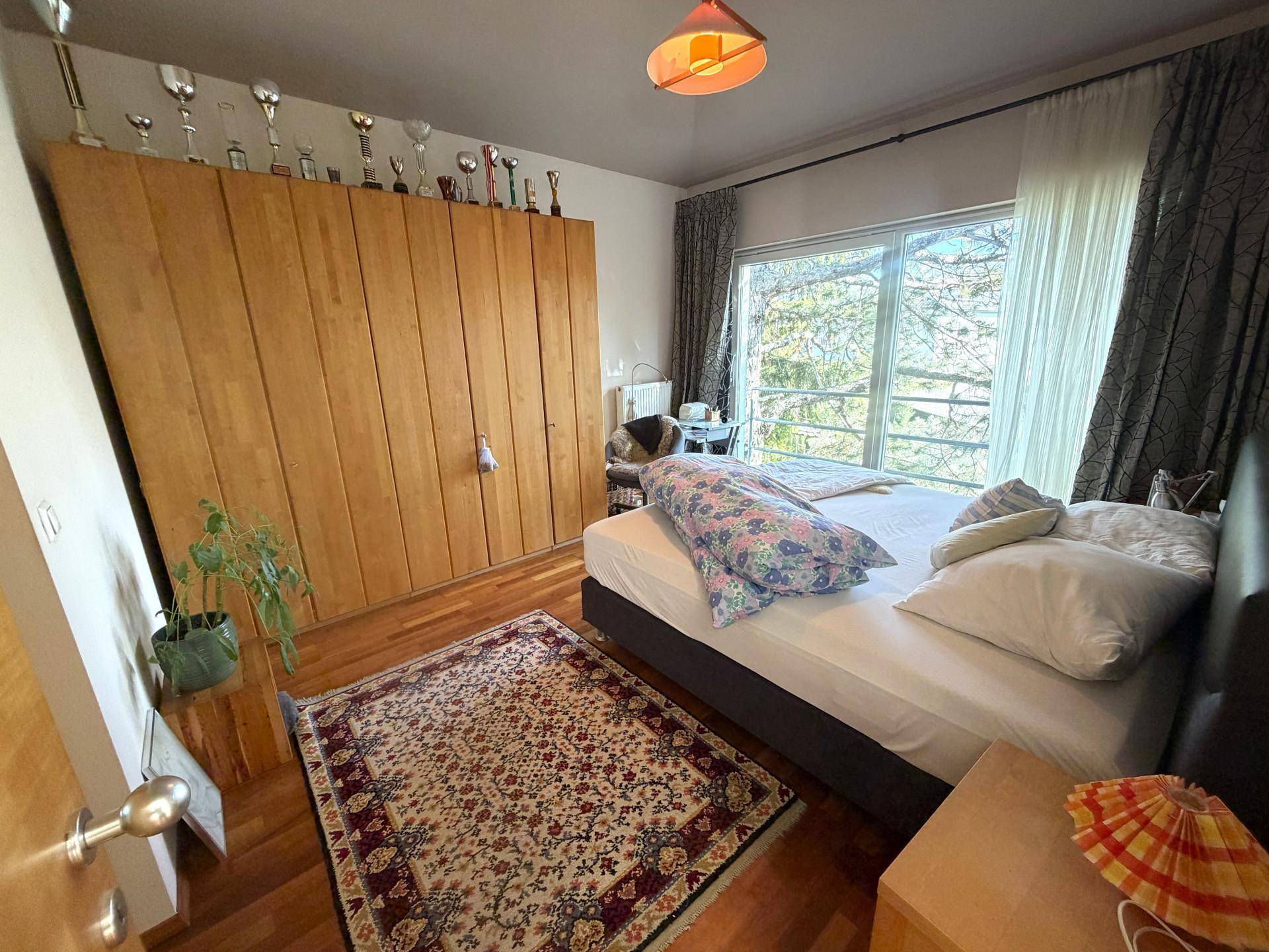 Geräumiges Schlafzimmer mit großen Einbauschränken, Doppelbett und Holzboden.