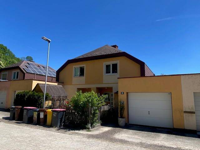 Vorderansicht des Hauses mit Garage und Photovoltaikanlage auf dem Dach.
