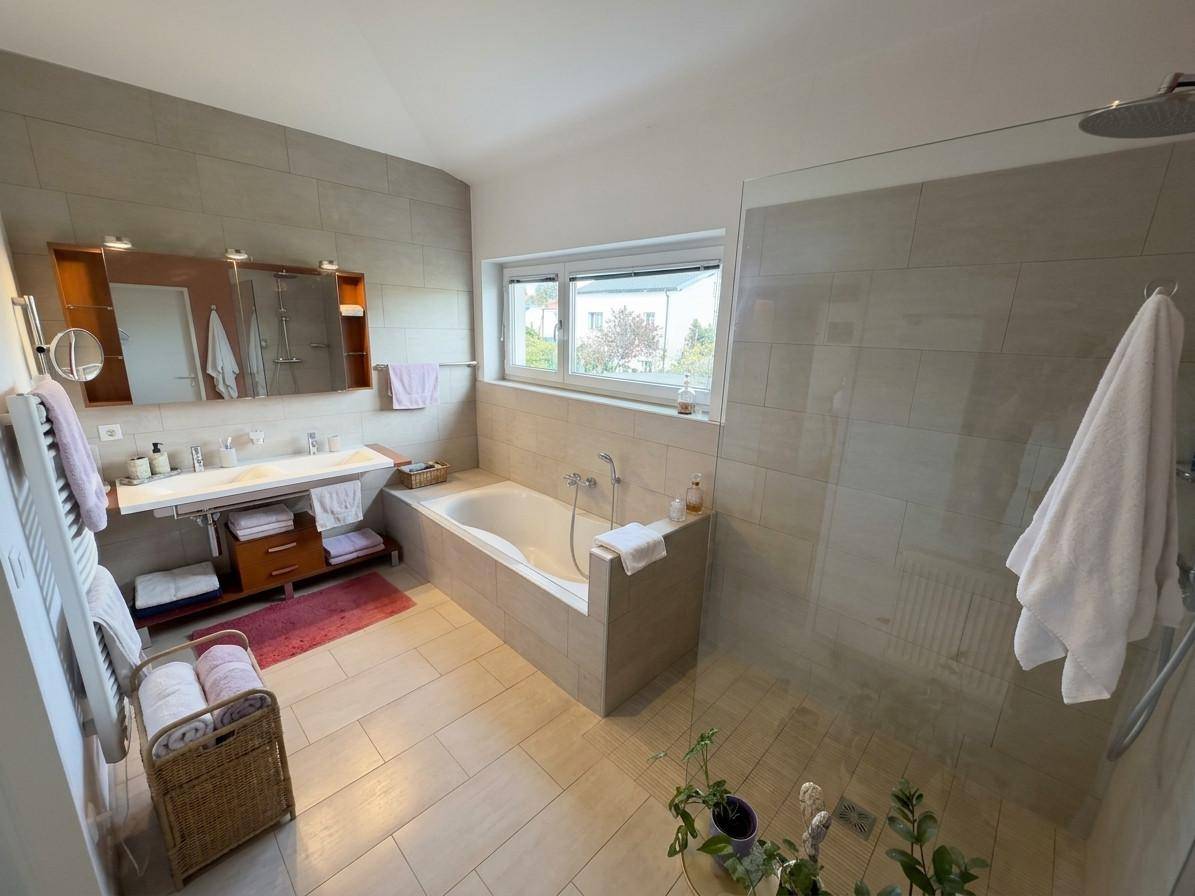 Modernes Badezimmer mit großer Badewanne, ebenerdiger Dusche und Doppelwaschbecken.