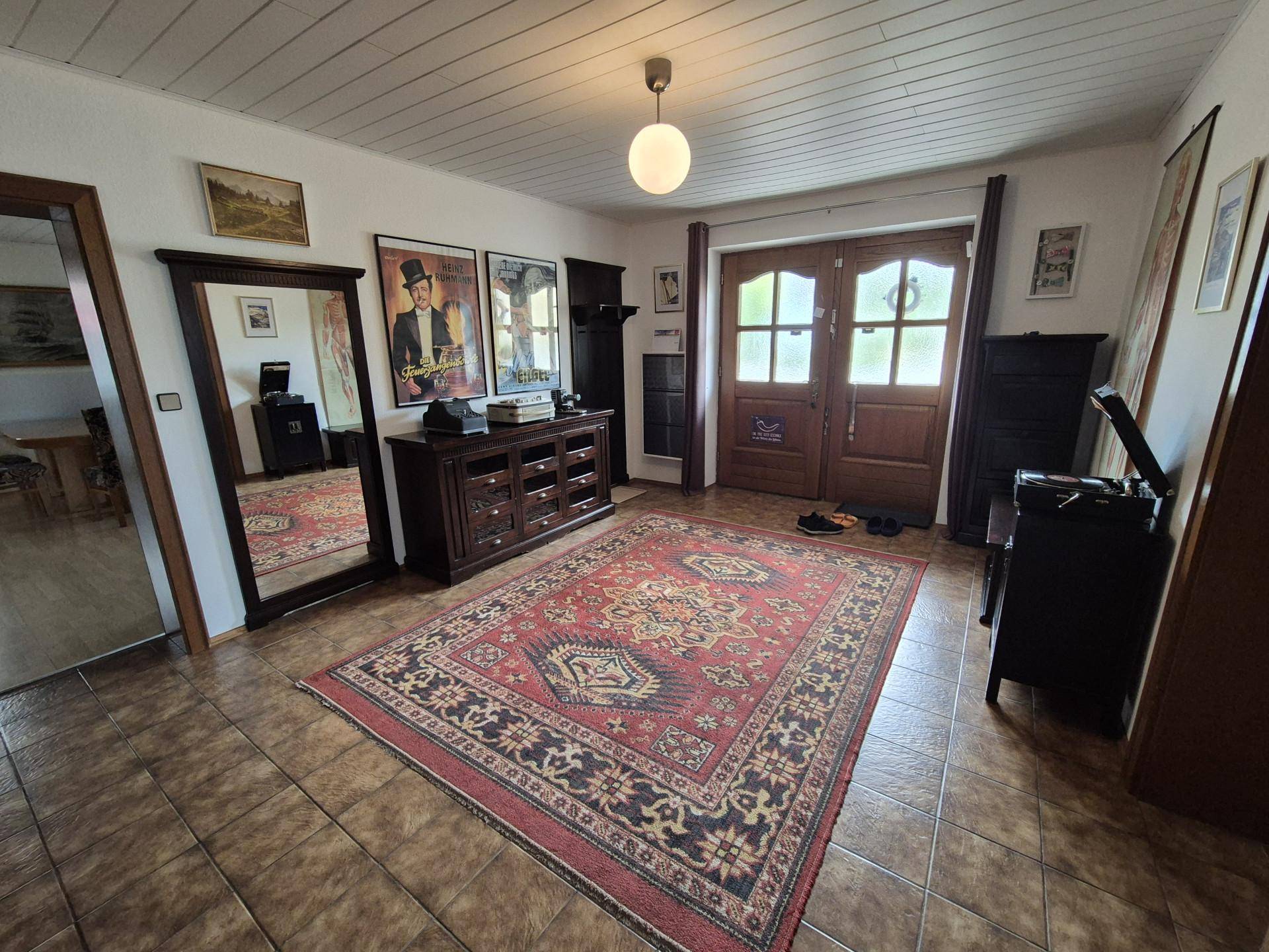 Geräumiger Flur mit Fliesenboden, Teppich und traditionellen Holzmöbeln.
