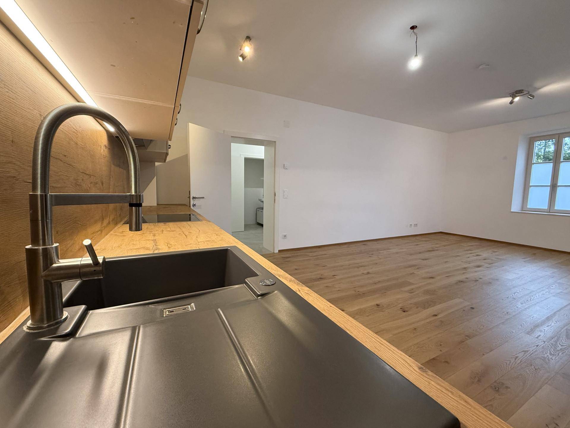Detailansicht der modernen Küchenspüle mit Armatur und Holzoptik-Arbeitsplatte.