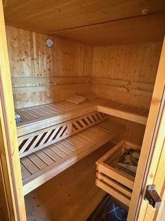 Private Sauna im Gartenhaus mit Holzverkleidung und mehreren Sitzebenen.