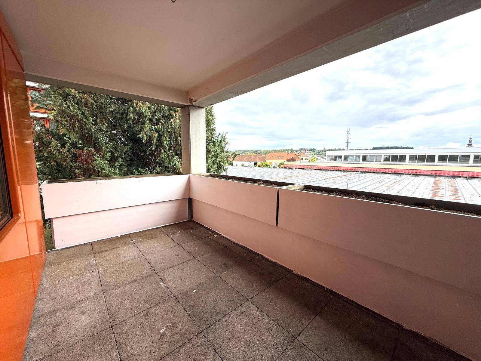 Geräumiger Balkon mit Fliesenboden und Pflanzkästen, bietet einen weiten Blick über die Umgebung.