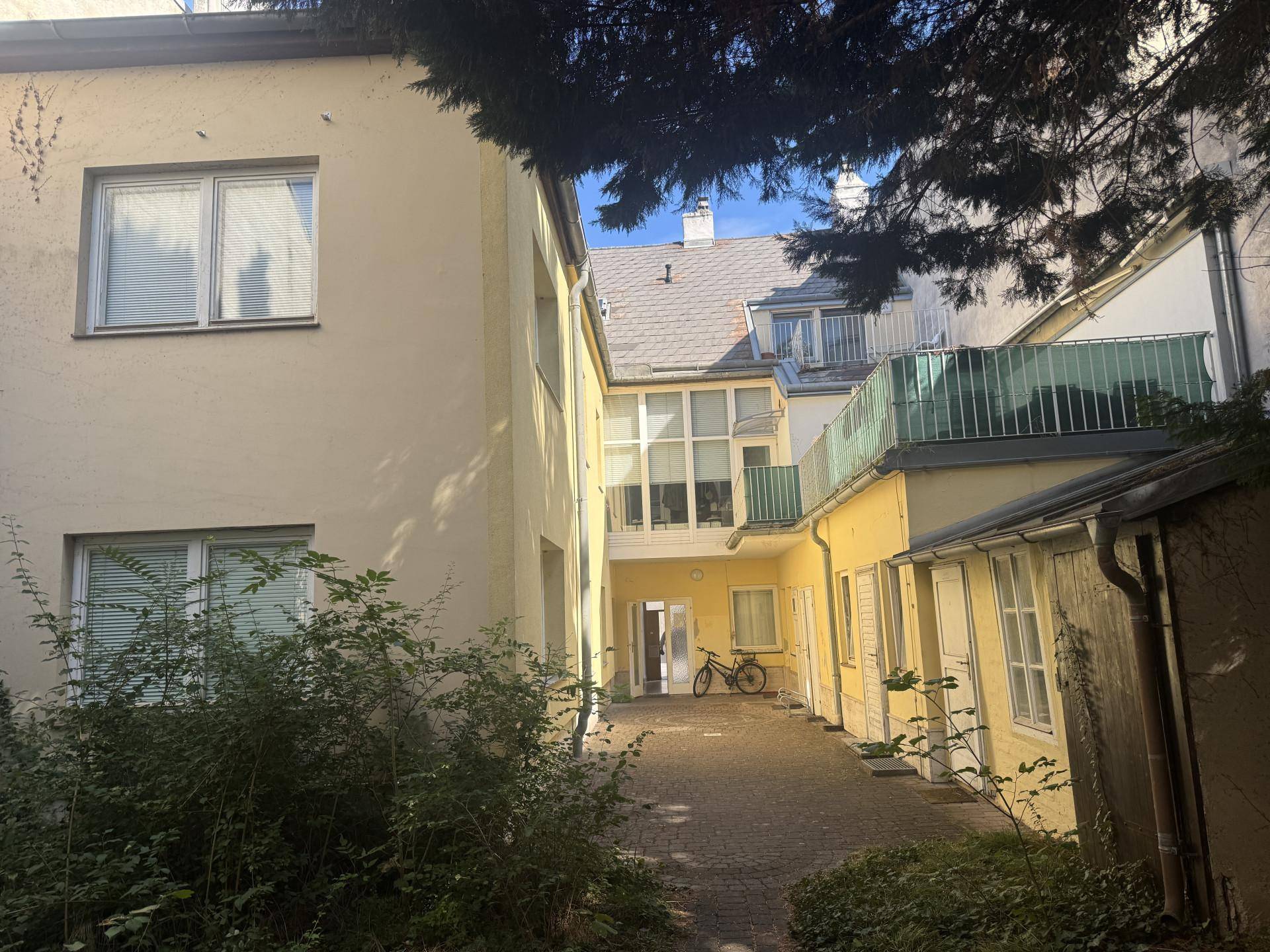 Innenhof mit gepflastertem Bereich, Fahrradabstellplatz und Blick auf die Gebäudefassaden.