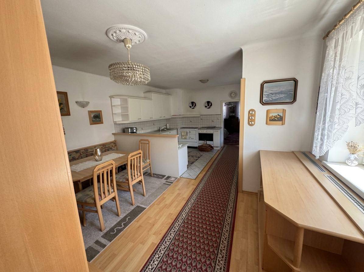 Traditionelle Wohnküche mit Essbereich, Holzmöbeln und einem Kronleuchter an der Decke.