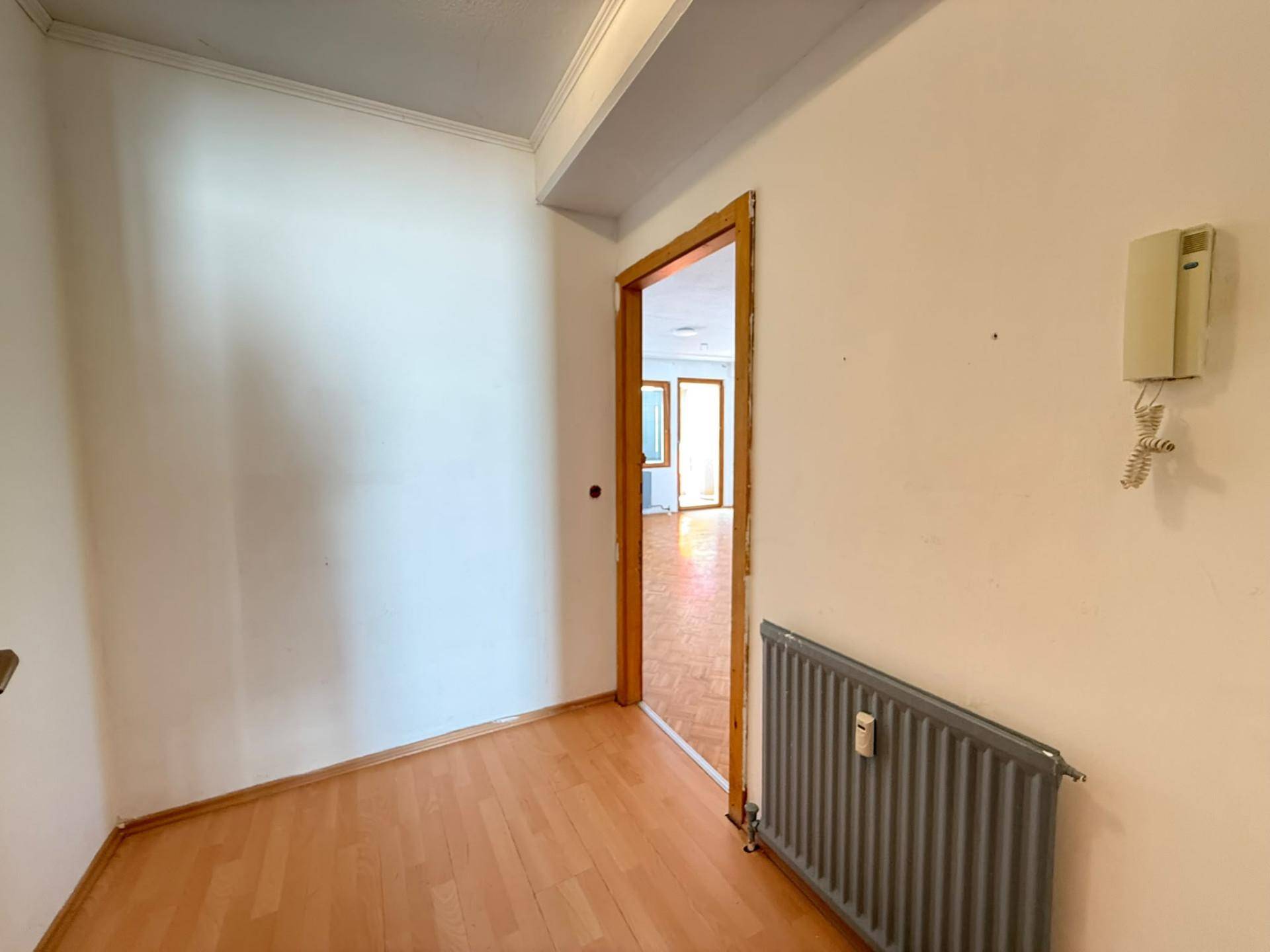 Heller Flur mit Parkettboden und Gegensprechanlage, verbindet die verschiedenen Räume der Wohnung.