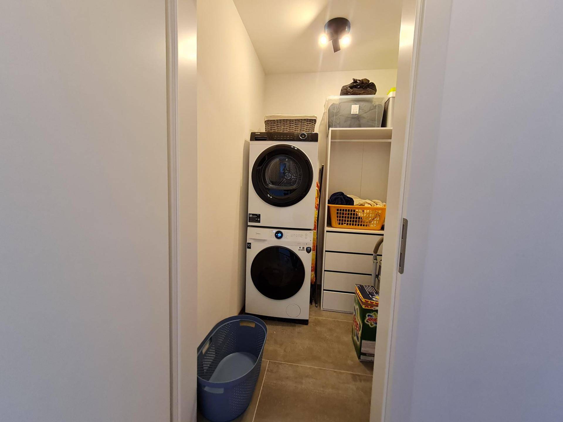 Praktischer Hauswirtschaftsraum mit Waschmaschine, Trockner und Stauraum.