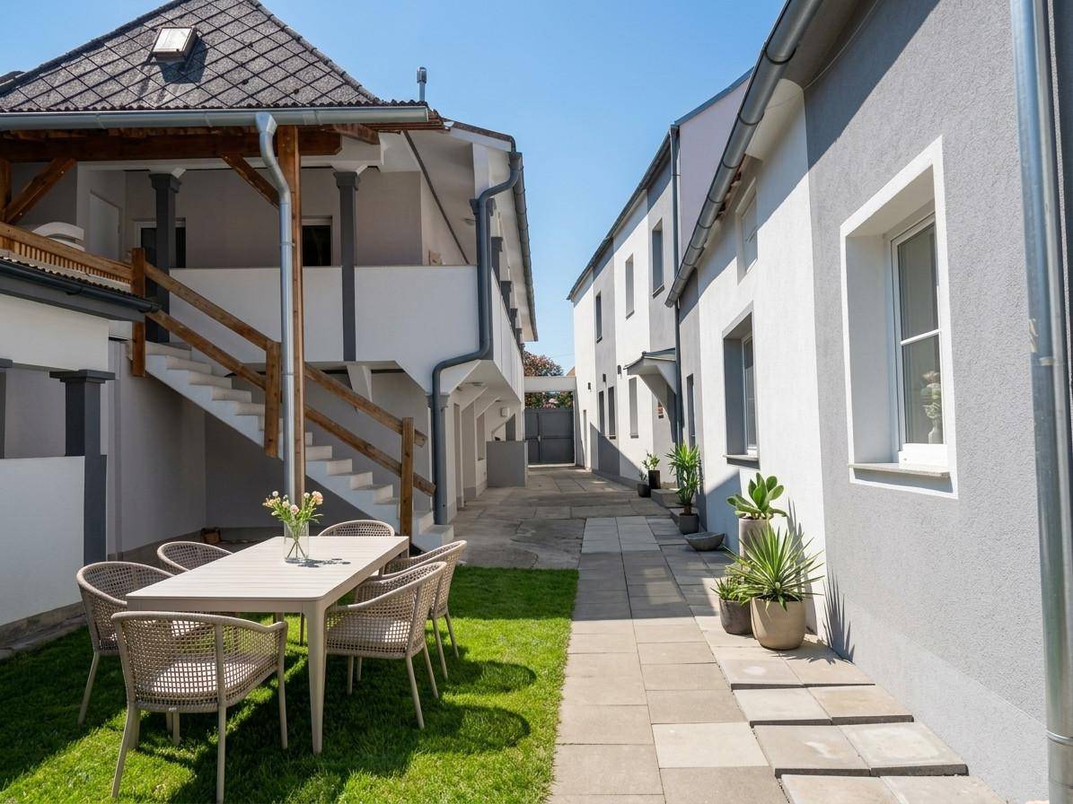 Gepflegter Gartenbereich mit Sitzgelegenheiten und Blick auf die umliegenden Gebäude.