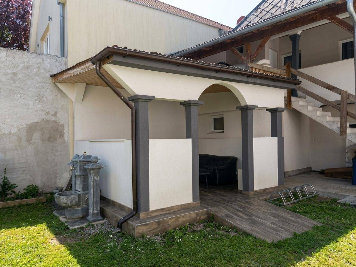 Überdachter Außenbereich mit Säulen und einer Rampe, ideal für entspannte Stunden im Freien.