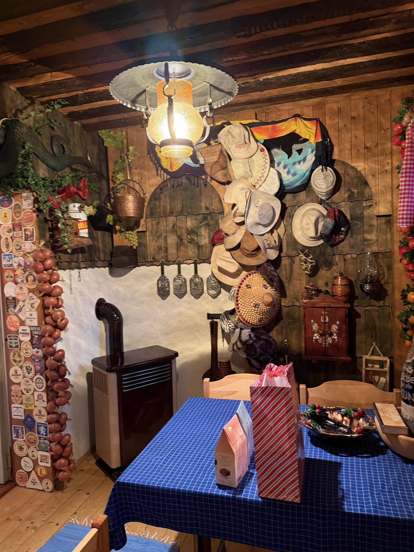 Rustikaler Essbereich mit Holzvertäfelung, traditioneller Dekoration und Ofen.