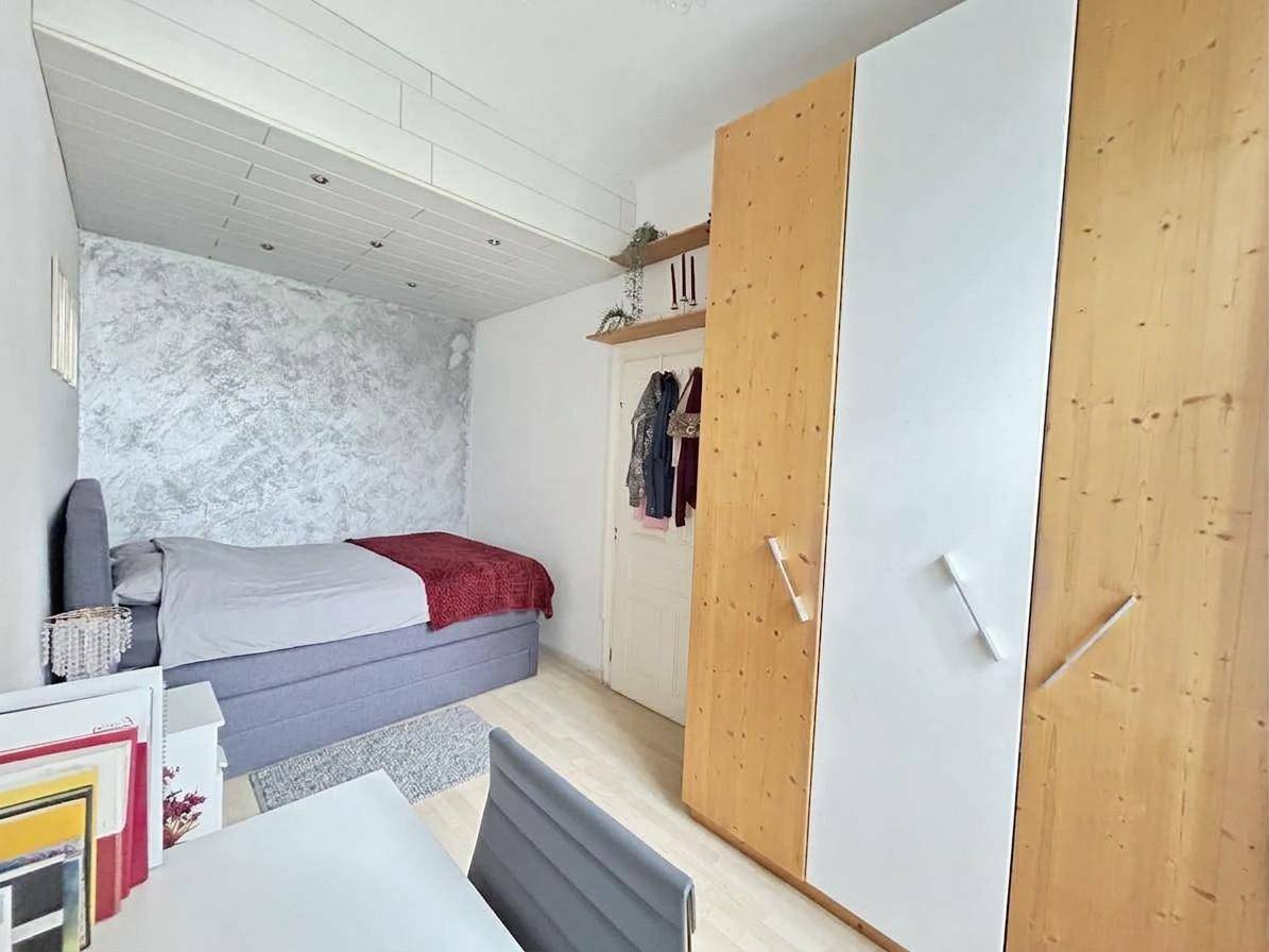 Schlafzimmer mit Doppelbett, Holzboden und großem Kleiderschrank.
