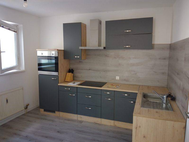 Voll ausgestattete moderne Küche mit Backofen, Induktionskochfeld, Dunstabzugshaube und Fenster.