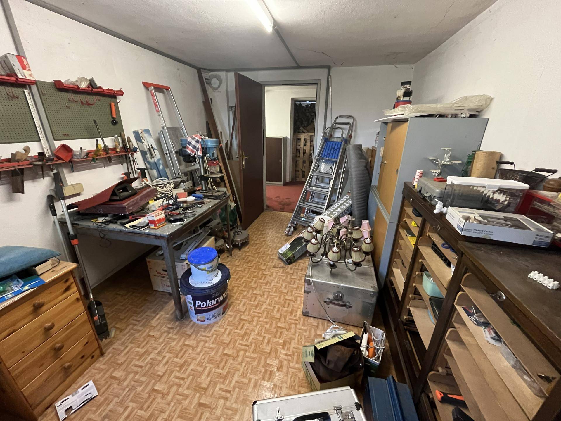 Werkstatt im Keller mit zahlreichen Werkzeugen, Geräten und Lagerflächen.