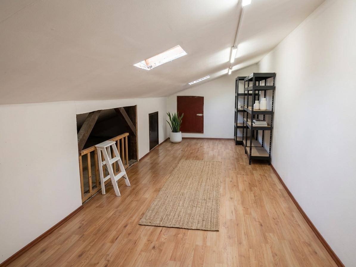 Ausgebauter Dachboden mit Holzboden, Dachfenstern und Stauraum unter der Schräge.